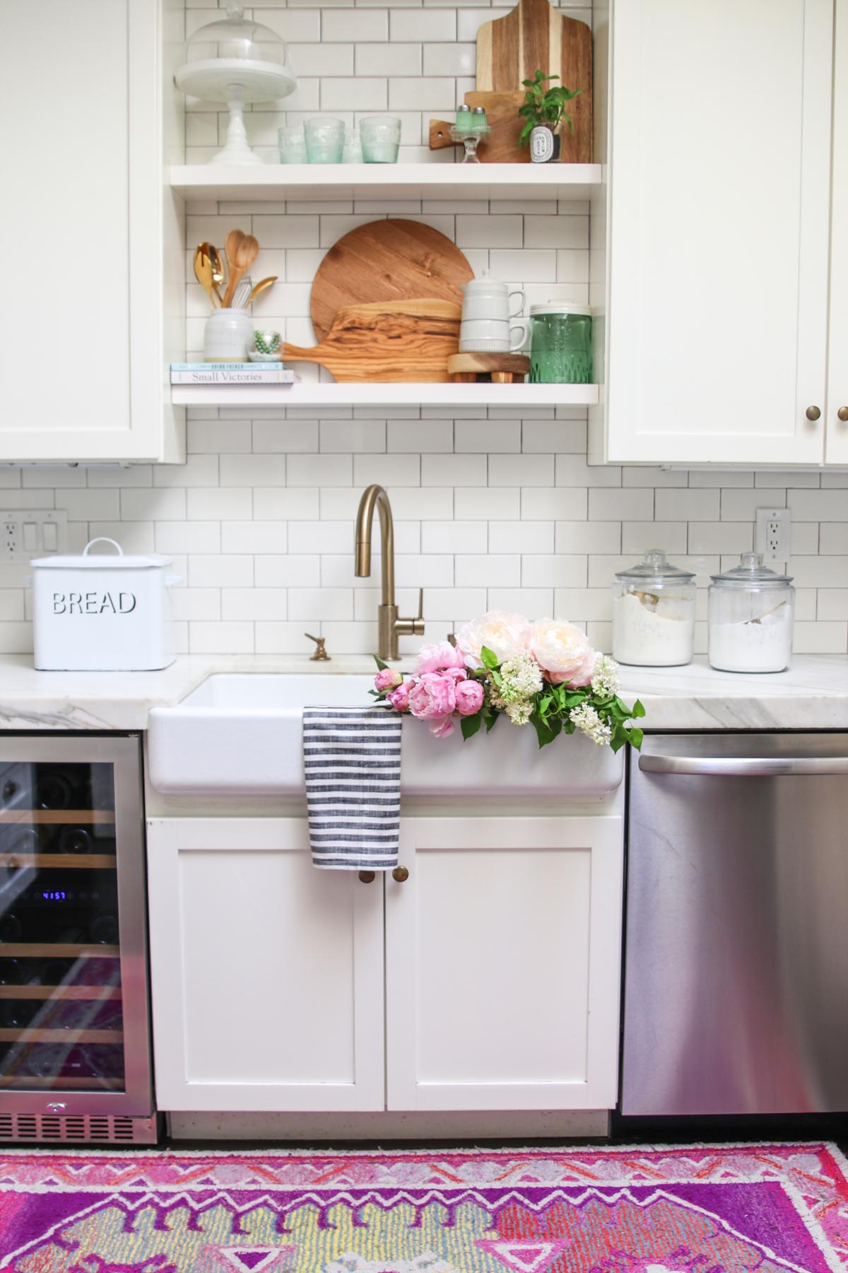 white kitchen with peonies in sink