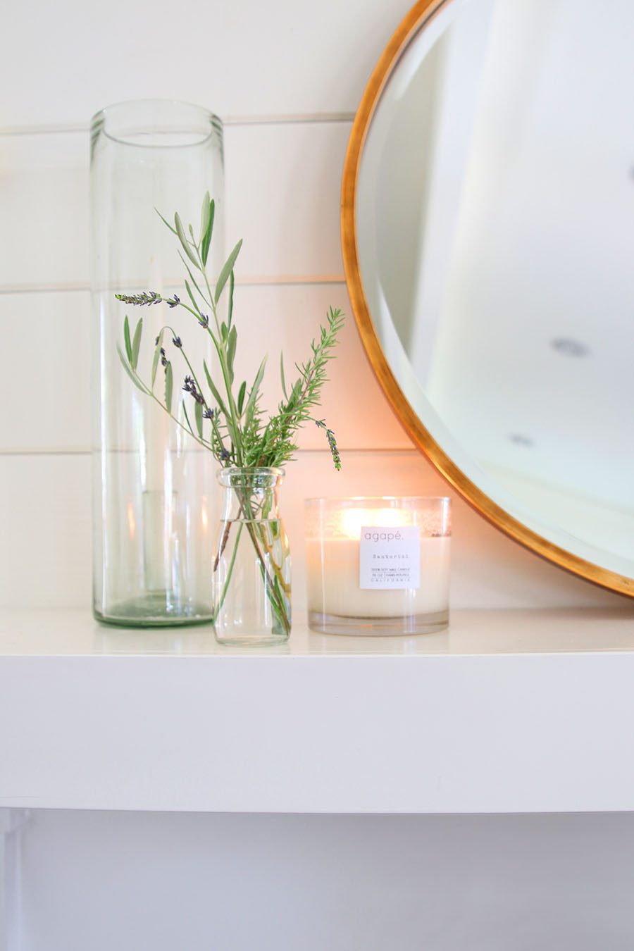 candle on mantel with lavender, rosemary and olive branches 