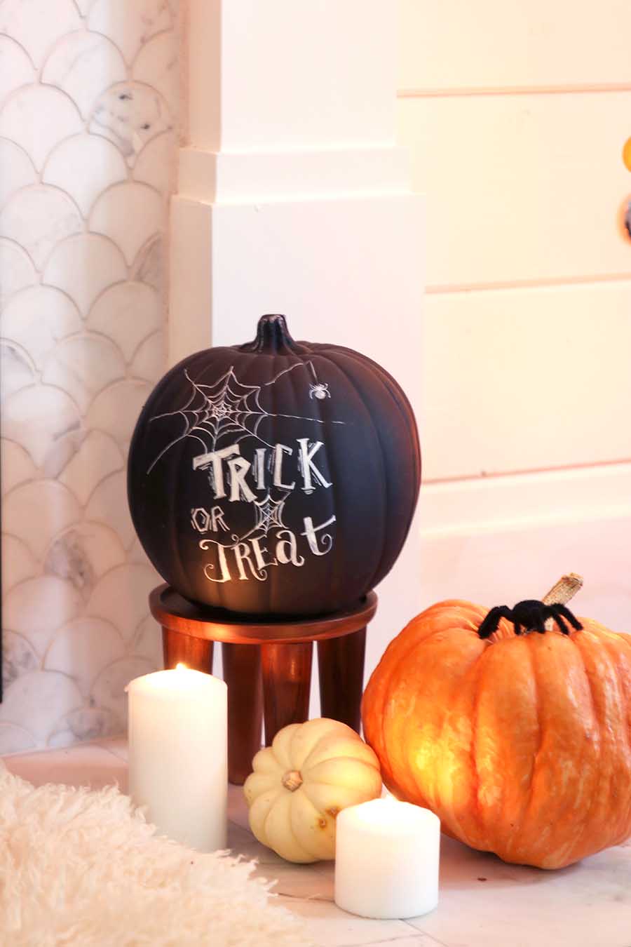 black and orange pumpkins on fireplace hearth