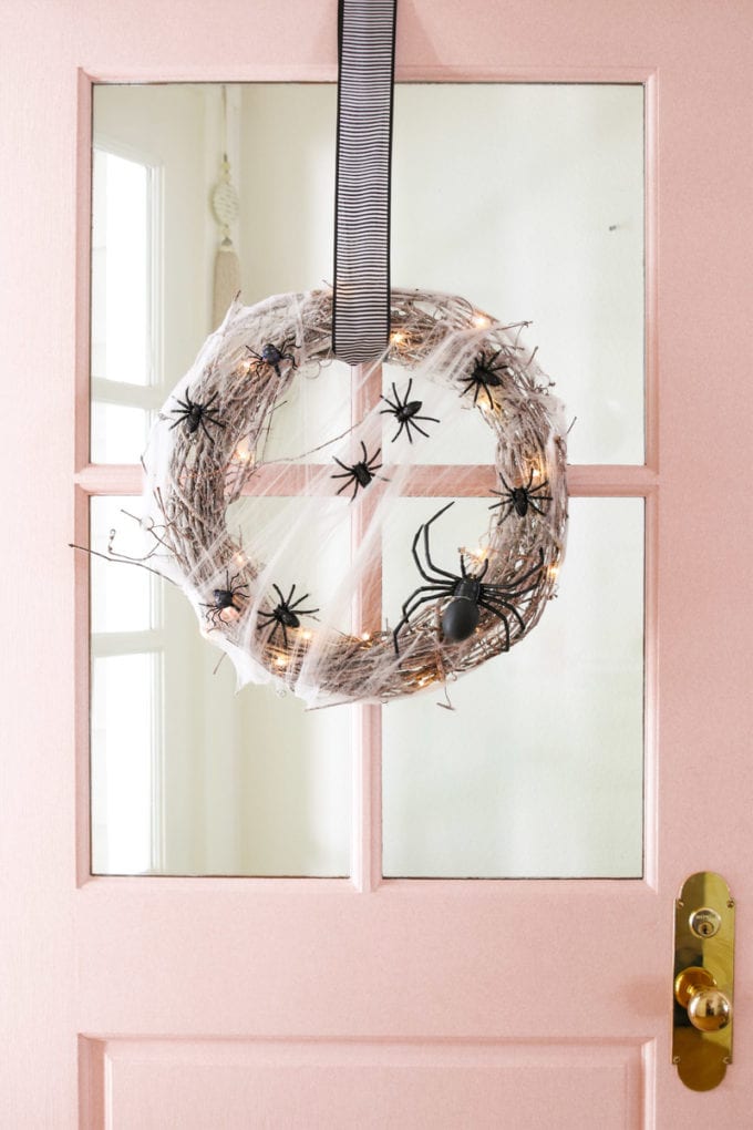 pink door with halloween wreath
